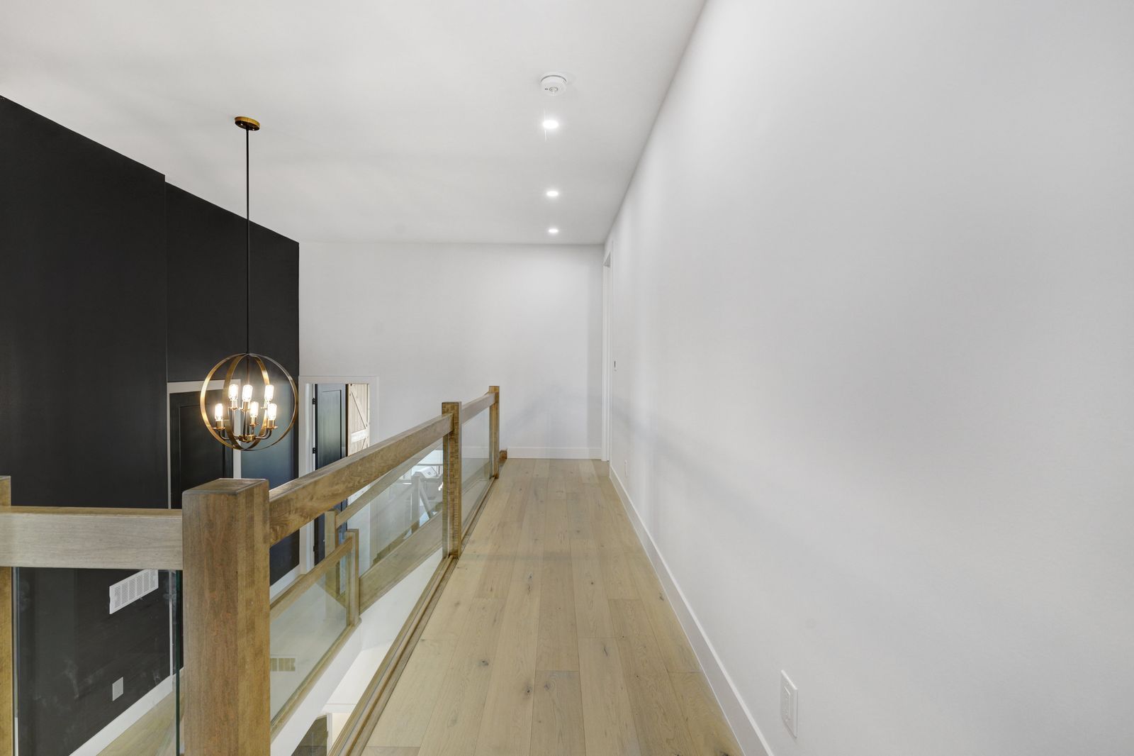 Upper landing with glass and oak railing in a completed Carnaby home